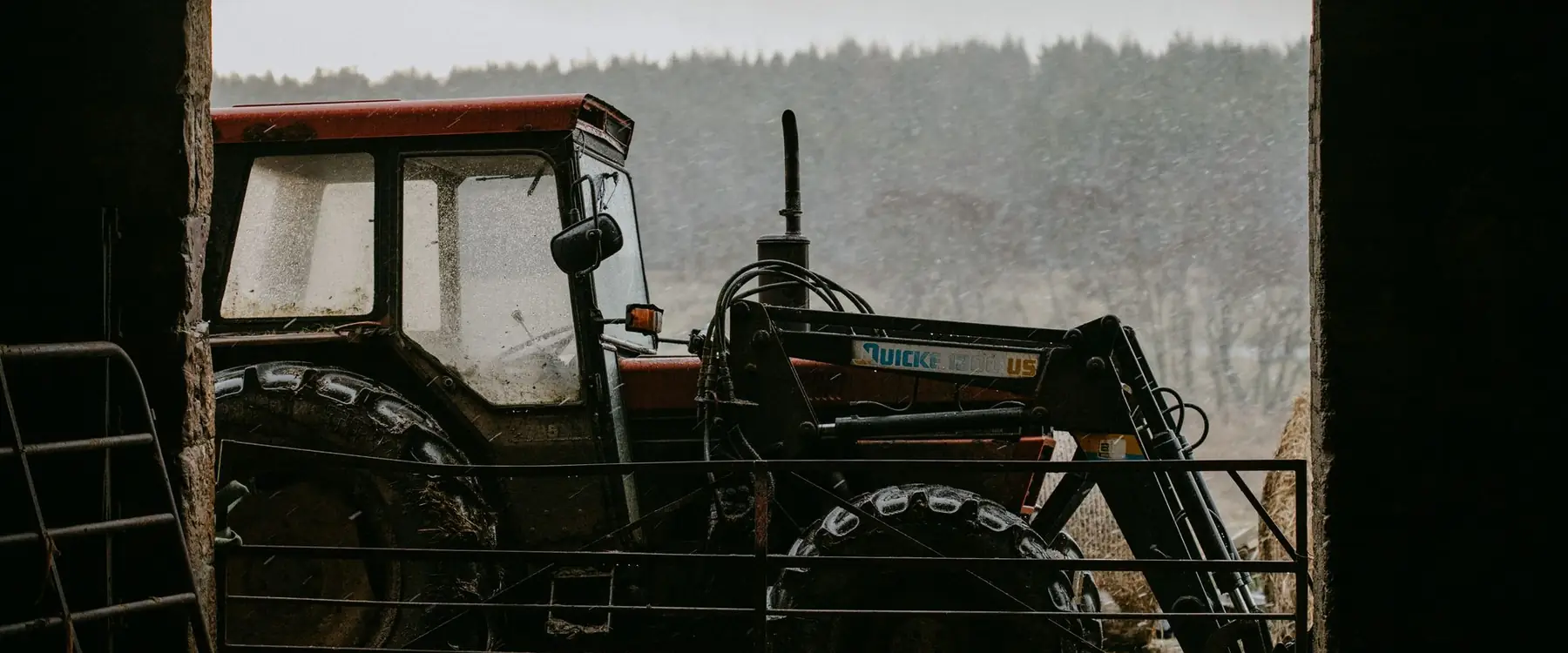 Tractor seen through the open bay of a farm shed